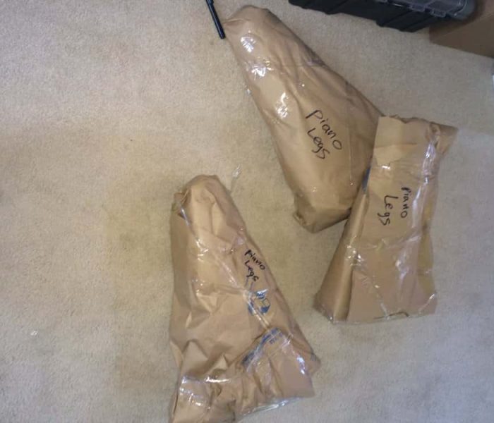 Baby Grand's Legs being wrapped in paper pads than blanketed or crated with cartons.